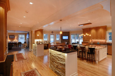 Example of a huge classic medium tone wood floor kitchen design in Boston with a double-bowl sink, recessed-panel cabinets, medium tone wood cabinets, granite countertops, multicolored backsplash, glass tile backsplash, stainless steel appliances and two islands