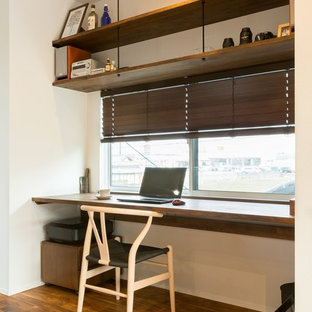 他の地域のモダンスタイルのおしゃれなホームオフィス・仕事部屋 (白い壁、無垢フローリング、造り付け机、茶色い床) の写真
