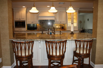 Inspiration for a large tropical u-shaped dark wood floor eat-in kitchen remodel in Miami with an undermount sink, raised-panel cabinets, white cabinets, quartzite countertops, multicolored backsplash, paneled appliances, an island and multicolored countertops