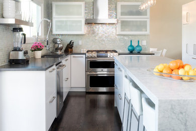 Example of a minimalist l-shaped dark wood floor eat-in kitchen design in Denver with an undermount sink, flat-panel cabinets, white cabinets, marble countertops, green backsplash, glass tile backsplash, stainless steel appliances and an island