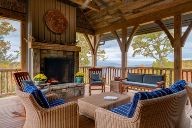 Example of a huge classic backyard deck design in Other with a fire pit and a roof extension