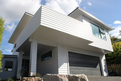 Mid-sized contemporary two-storey white house exterior in Other.