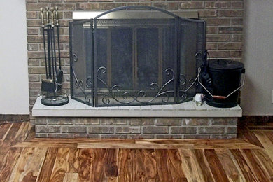 Elegant medium tone wood floor and brown floor living room photo in Chicago with beige walls, a standard fireplace and a brick fireplace