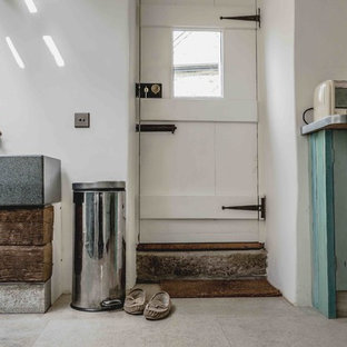 Photo of a medium sized rustic l-shaped utility room in Devon with an utility sink, recessed-panel cabinets, distressed cabinets, zinc worktops, white walls, limestone flooring, a side by side washer and dryer and beige floors.