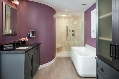 Inspiration for a large contemporary master bathroom in Other with shaker cabinets, grey cabinets, a freestanding tub, a curbless shower, a one-piece toilet, purple walls, an undermount sink, granite benchtops, beige tile, marble, light hardwood floors, beige floor and an open shower.