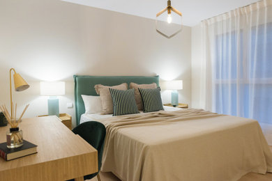 Imagen de dormitorio principal y blanco actual de tamaño medio con paredes beige, suelo de madera clara y con escritorio