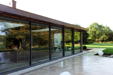 Ejemplo de fachada minimalista extra grande con revestimiento de vidrio
