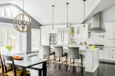 Large transitional medium tone wood floor kitchen photo in Boston with recessed-panel cabinets, white backsplash and an island