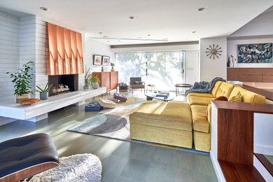 Inspiration for a mid-sized mid-century modern open concept cork floor, gray floor and brick wall family room remodel in San Diego with white walls, a standard fireplace, a metal fireplace and a concealed tv