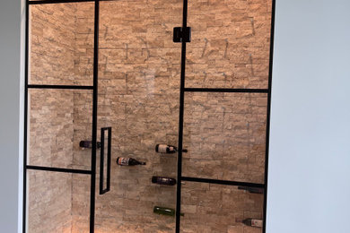 Inspiration for a small modern wine cellar in Cincinnati with medium hardwood flooring, display racks and brown floors.