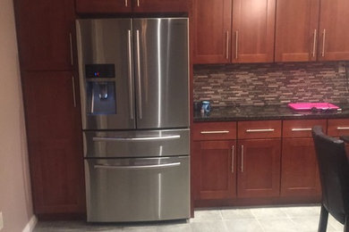 Inspiration for a modern eat-in kitchen remodel in Providence with flat-panel cabinets, dark wood cabinets, granite countertops, multicolored backsplash, glass tile backsplash and an island