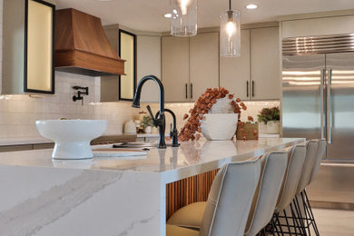 Large transitional l-shaped laminate floor and brown floor open concept kitchen photo in Phoenix with an undermount sink, shaker cabinets, beige cabinets, quartz countertops, white backsplash, porcelain backsplash, stainless steel appliances, an island and white countertops