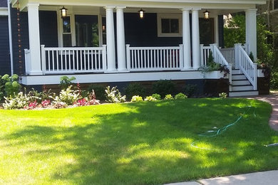 Mid-sized elegant concrete paver front porch photo in Chicago with a roof extension