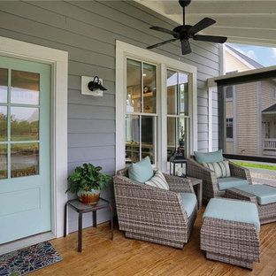 Ispirazione per un grande portico stile americano davanti casa con pedane, un tetto a sbalzo e parapetto in legno
