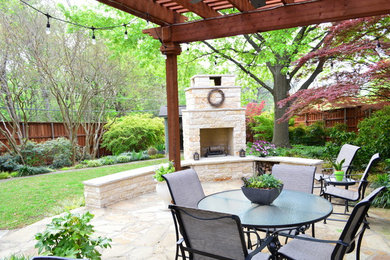 Photo of a large eclectic backyard patio in Dallas with with fireplace.