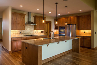 Kitchen pantry - mid-sized rustic l-shaped medium tone wood floor kitchen pantry idea in Other with an undermount sink, recessed-panel cabinets, medium tone wood cabinets, granite countertops, multicolored backsplash, stone tile backsplash, stainless steel appliances and an island