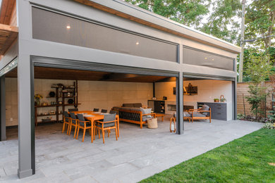 Large minimalist porcelain tile and gray floor sunroom photo in Toronto with a standard fireplace, a stone fireplace and a standard ceiling