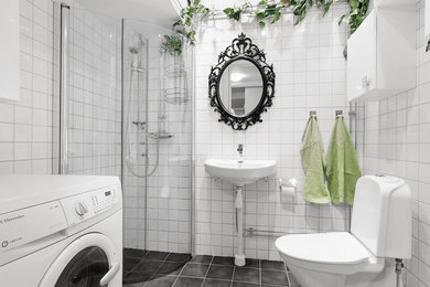 Mid-sized traditional 3/4 bathroom in Stockholm with flat-panel cabinets, white cabinets, a corner shower, a two-piece toilet, black and white tile, white walls, a pedestal sink, ceramic tile and a hinged shower door.