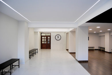 Imagen de vestíbulo contemporáneo de tamaño medio con paredes blancas, suelo de baldosas de porcelana, puerta doble y puerta de madera oscura