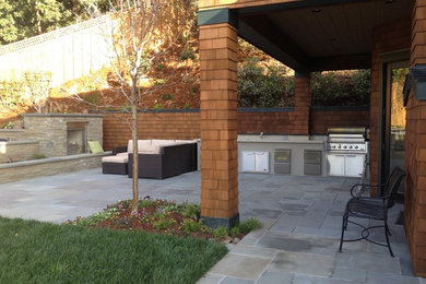 Design ideas for a large country backyard patio in San Francisco with an outdoor kitchen, natural stone pavers and a roof extension.