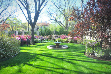 Large transitional backyard partial sun formal garden in Dallas with a water feature.