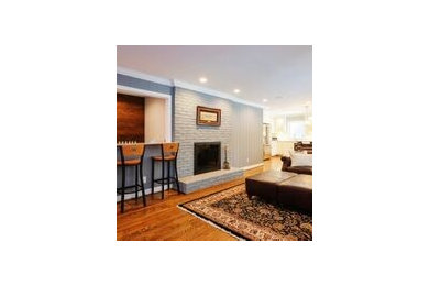 Inspiration for a large timeless open concept dark wood floor and brown floor family room remodel in Other with gray walls, a standard fireplace, a brick fireplace and a wall-mounted tv