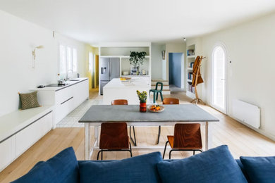 Idée de décoration pour une grande salle à manger ouverte sur le salon design avec un mur beige, parquet clair et un sol marron.