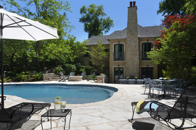 Example of a large classic backyard stone and custom-shaped natural pool fountain design in St Louis