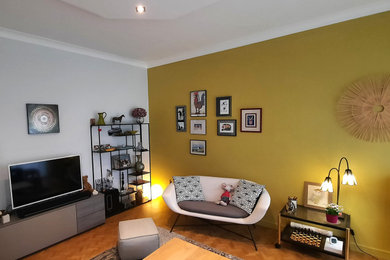 Cette photo montre un salon gris et jaune tendance avec un mur jaune.