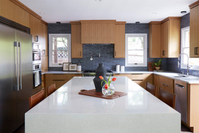 Eat-in kitchen - contemporary u-shaped eat-in kitchen idea in Chicago with light wood cabinets, quartzite countertops, blue backsplash, ceramic backsplash, stainless steel appliances, an island and white countertops