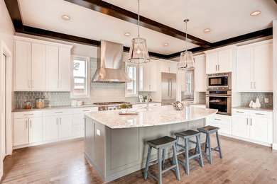 Example of a large transitional l-shaped medium tone wood floor open concept kitchen design in Denver with an undermount sink, shaker cabinets, white cabinets, granite countertops, gray backsplash, glass tile backsplash, stainless steel appliances and an island