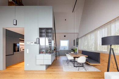Offenes Modernes Esszimmer mit weißer Wandfarbe, dunklem Holzboden, braunem Boden und Holzwänden in Sonstige