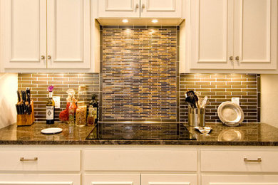 Eat-in kitchen - mid-sized transitional u-shaped medium tone wood floor eat-in kitchen idea in Austin with a double-bowl sink, raised-panel cabinets, white cabinets, brown backsplash, ceramic backsplash, stainless steel appliances, a peninsula and granite countertops