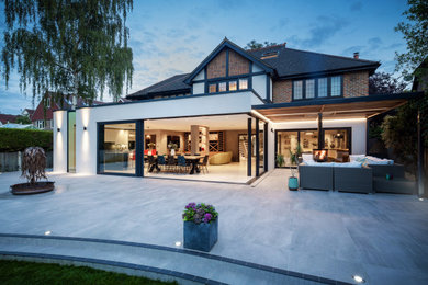 Large contemporary bungalow render detached house in Surrey with a grey roof.