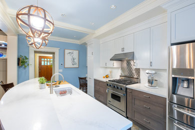 Mid-sized transitional galley ceramic tile, multicolored floor and coffered ceiling eat-in kitchen photo in Vancouver with an undermount sink, recessed-panel cabinets, medium tone wood cabinets, quartz countertops, white backsplash, ceramic backsplash, stainless steel appliances, an island and white countertops
