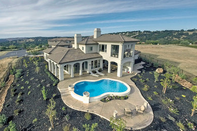 Large mediterranean beige two-story stucco exterior home idea in Sacramento