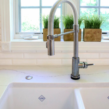White Kitchen with Gray Quartz Countertops, Farmhouse Sink and Hardwood Floors
