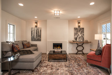 Trendy open concept light wood floor living room photo in Other with white walls, a standard fireplace, a plaster fireplace and a wall-mounted tv