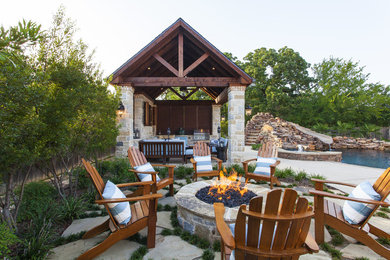 Inspiration for a large craftsman backyard stone patio remodel in Tampa with a fire pit and no cover