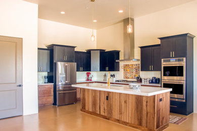 Inspiration for a large contemporary l-shaped concrete floor, yellow floor and vaulted ceiling eat-in kitchen remodel in Other with an undermount sink, shaker cabinets, black cabinets, copper countertops, beige backsplash, porcelain backsplash, stainless steel appliances, an island and yellow countertops