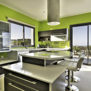 Mittelgroße Mid-Century Küche in L-Form mit Vorratsschrank, Glasfronten, Edelstahlfronten, Mineralwerkstoff-Arbeitsplatte, Küchengeräten aus Edelstahl und Kücheninsel in Vancouver