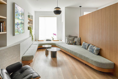Photo of a contemporary living room in Toronto with white walls, medium hardwood floors and brown floor.