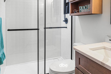 Mid-sized transitional kids' white tile brown floor and single-sink bathroom photo in Other with shaker cabinets, brown cabinets, a one-piece toilet, white walls, an undermount sink, quartz countertops, white countertops, a niche and a built-in vanity