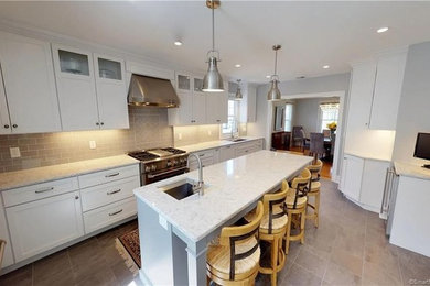Photo of a mid-sized traditional u-shaped separate kitchen in Other with stainless steel appliances, an undermount sink, shaker cabinets, white cabinets, quartz benchtops, grey splashback, subway tile splashback, porcelain floors, with island, brown floor and white benchtop.
