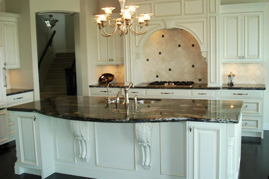 Mid-sized elegant single-wall dark wood floor open concept kitchen photo in Vancouver with a double-bowl sink, raised-panel cabinets, white cabinets, beige backsplash, ceramic backsplash, paneled appliances, an island and granite countertops