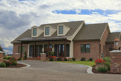 Large farmhouse one-story brick exterior home photo in Other
