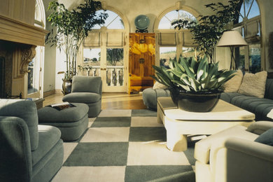 Living room - large mediterranean formal and enclosed light wood floor and brown floor living room idea in Los Angeles with beige walls, a standard fireplace, a wood fireplace surround and no tv