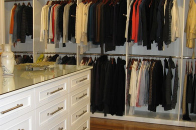 Example of a large classic gender-neutral medium tone wood floor and brown floor dressing room design in Los Angeles with white cabinets and recessed-panel cabinets