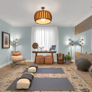 デンバーの中サイズのコンテンポラリースタイルのおしゃれなヨガスタジオ (青い壁、ラミネートの床、ベージュの床) の写真