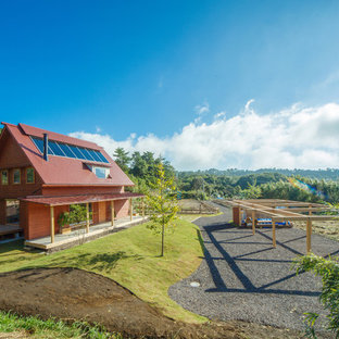 福岡のアジアンスタイルのおしゃれな二階建ての家 (赤い外壁、木材サイディング、切妻屋根、戸建、金属屋根) の写真